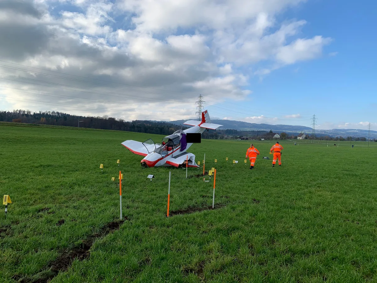 Man sieht ein auf einer Wiese abgestürzte Kleinflugzeug.