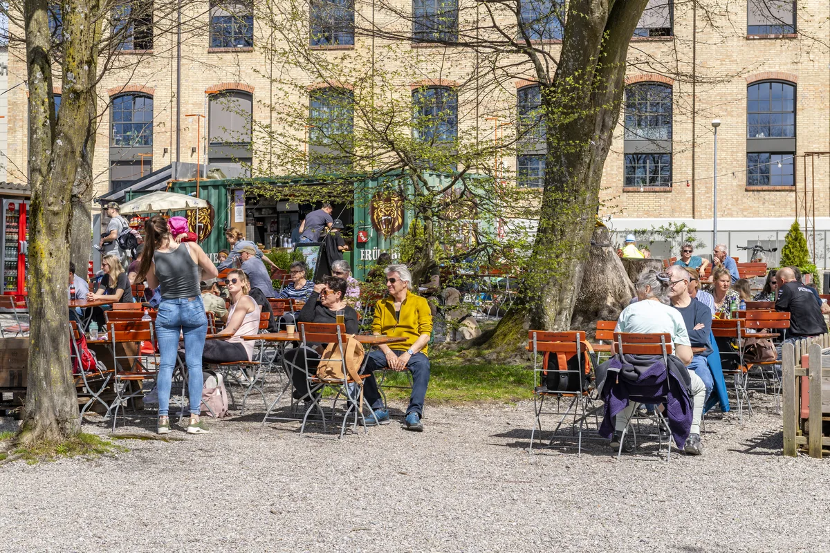 Menschen, die in kurzen T-Shirts im Bistro am See sitzen.