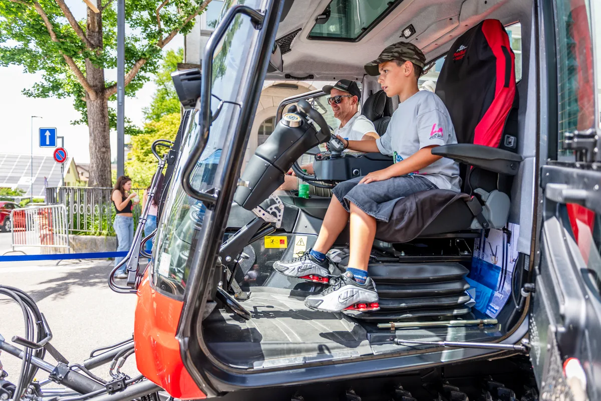 Der Pistenbully am Stand des Skiclubs am Bachtel ist im Sommerbetrieb. Jeremy versucht, durch feine Bewegungen der Frontschaufel eine Kugel durch das Labyrinth zu bringen. Die Bestzeiten liegen unter einer Minute. Ein Kind und ein Mann im Pistenbully.