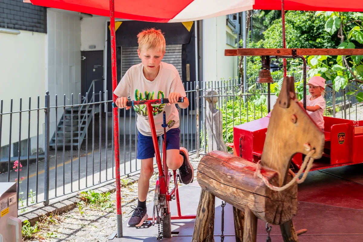 Das Karussell, das aus dem vergangenen Jahrhundert stammt, wird von Dario mit eigener Muskelkraft angetrieben. Ein Junge auf einem Karussell.