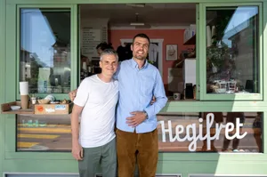 26259562-4 Fabian von Rechenberg und This Schälchli (rechts) vor dem Kaffeefenster Hegifret am Hegibachplatz in Zürich.