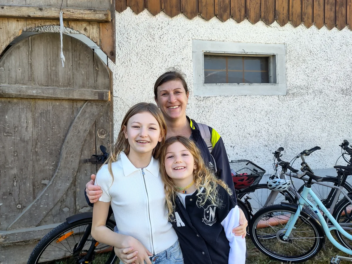 Man sieht eine Frau mit ihren zwei Töchtern.