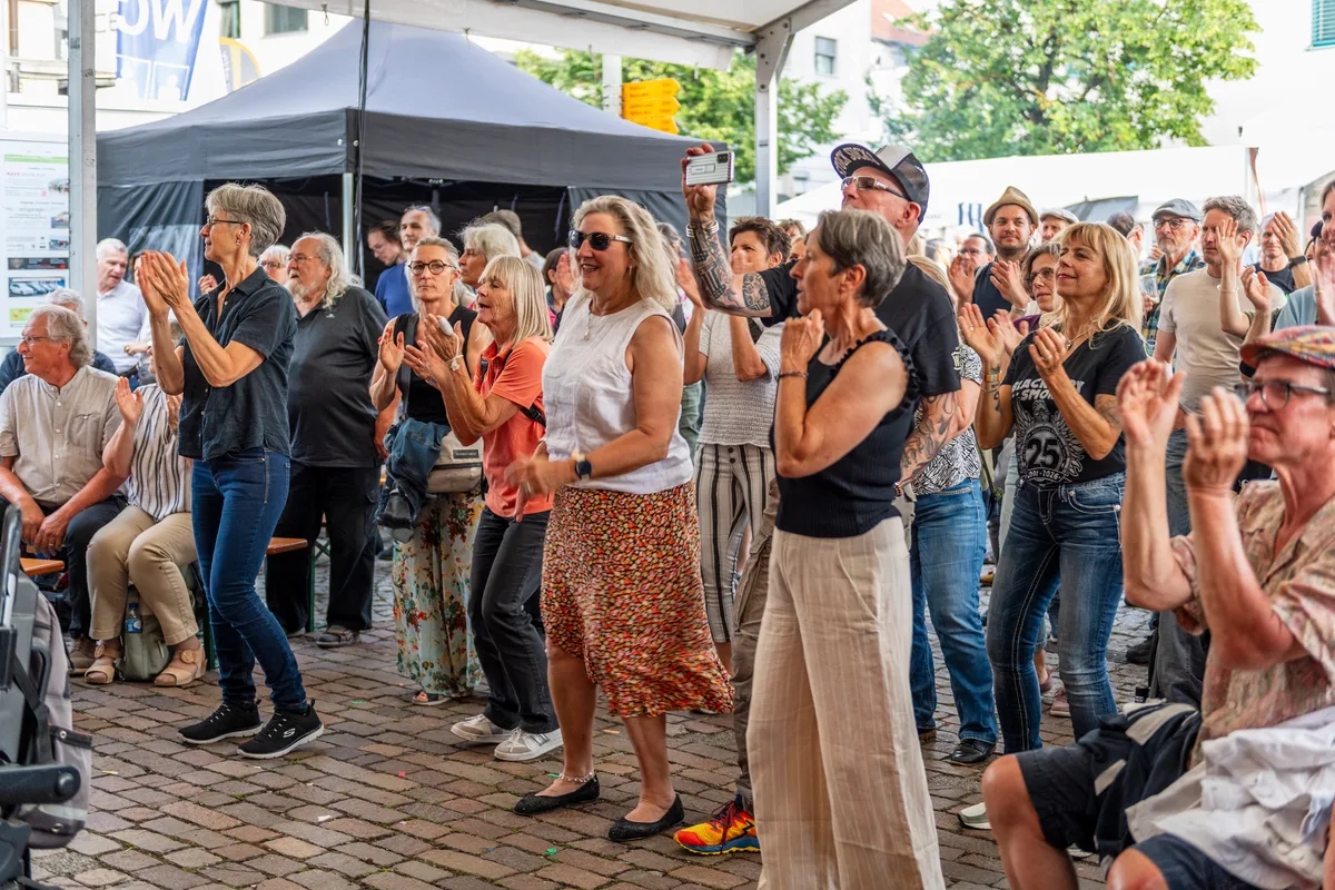 Das gesetztere Publikum tanzte gerne zum funkigen Sound von Sugarpuffs. Erwachsene Leute tanzen an einem Dorffest vor einer Bühne.
