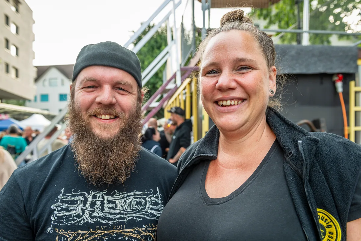 Die beiden ehemaligen Arbeitskollegen Sven und Jenny haben sich an der Bar der Guggemusig Robehuuse getroffen. Das Stadtfest ist für die beiden ein fester Pflichttermin in der Agenda. Ein Mann und eine Frau in schwarz gekleidet lachen in die Kamera.