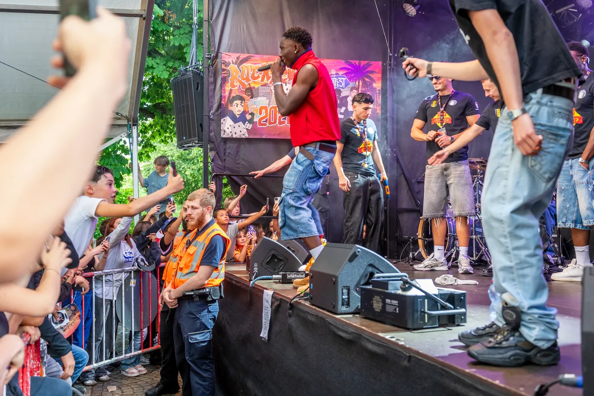 Die Männer von der Security waren offensichtlich keine Showeinlage. Ein Rapper auf einer kleinen Bühne vor dicht gedrängtem Publikum.