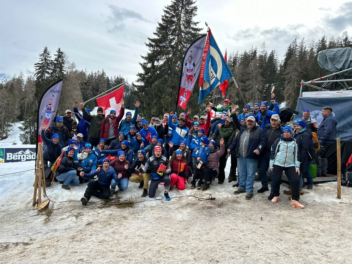 Eine grössere Gruppe Menschen posiert auf einem Schneefeld.