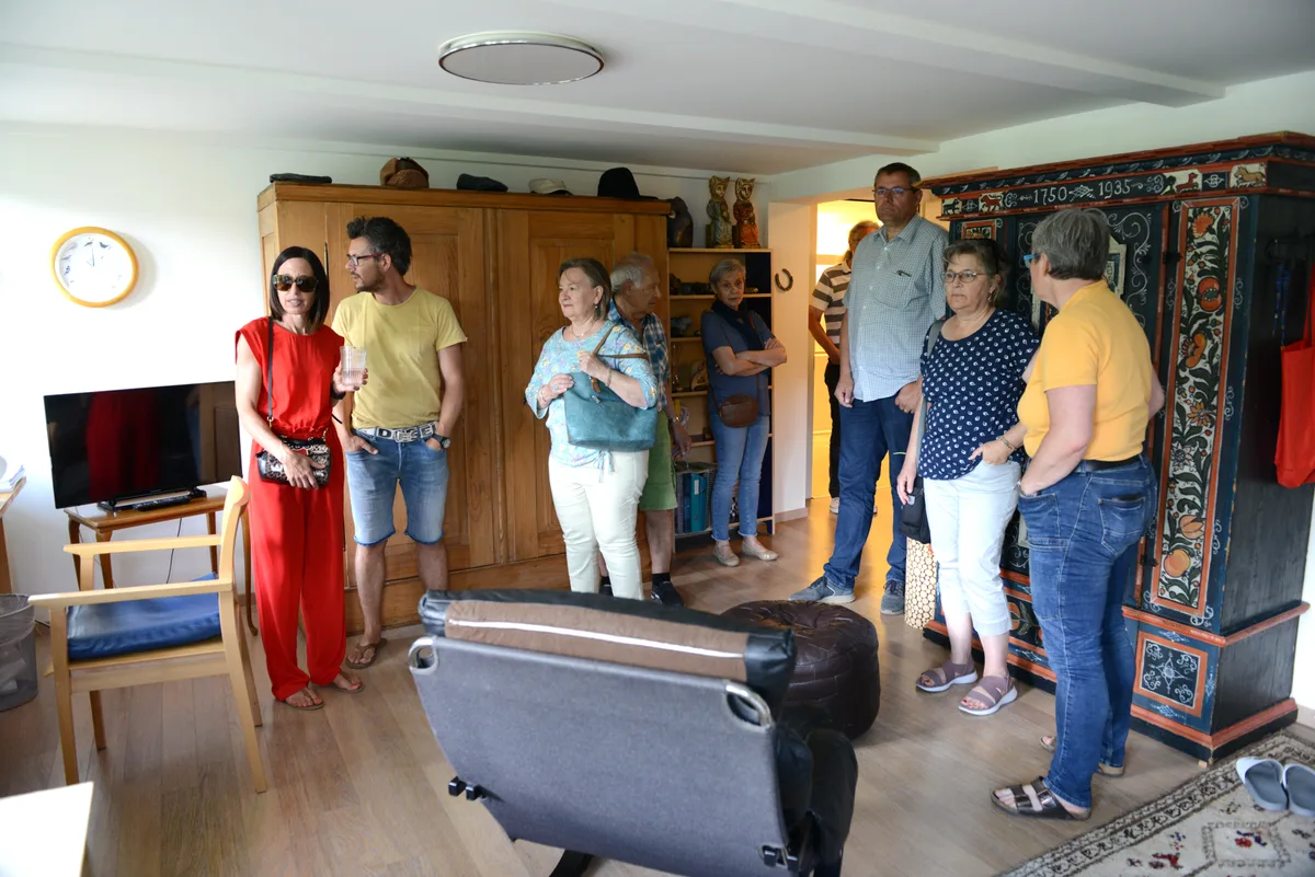 Junge und alte Menschen sehen sich ein Zimmer an.
