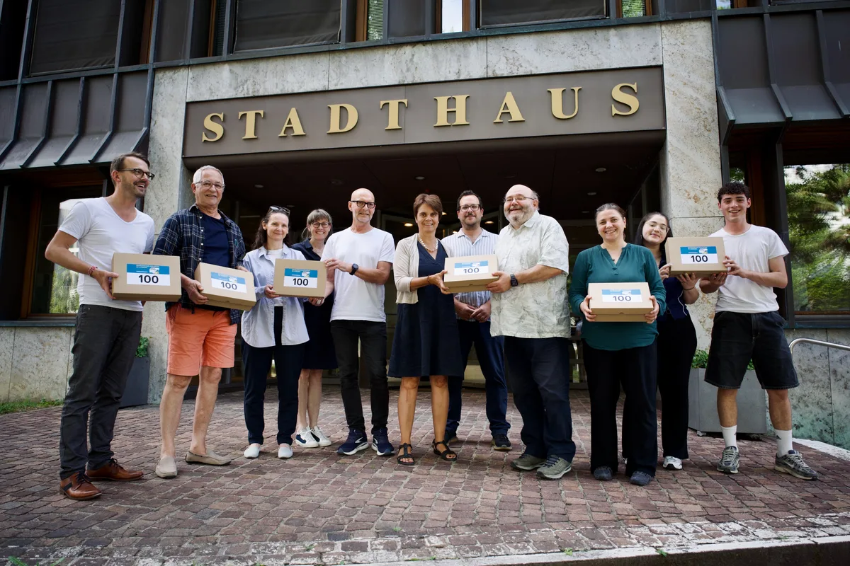Das Initiativkomitee übergibt die Unterschriften an Stadtpräsident Pascal Bassu (Vierter von rechts) und Stadtschreiberin Melanie Imfeld (Vierte von links). 