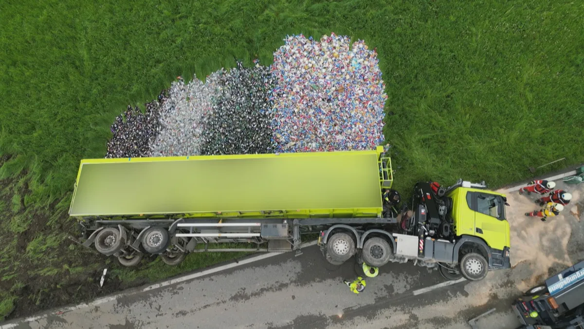Verunfallter LKW liegt auf der Seite - farbige Scherben sind auf der Wiese verstreut. Verunfallter LKW liegt auf der Seite - farbige Scherben sind auf der Wiese verstreut.