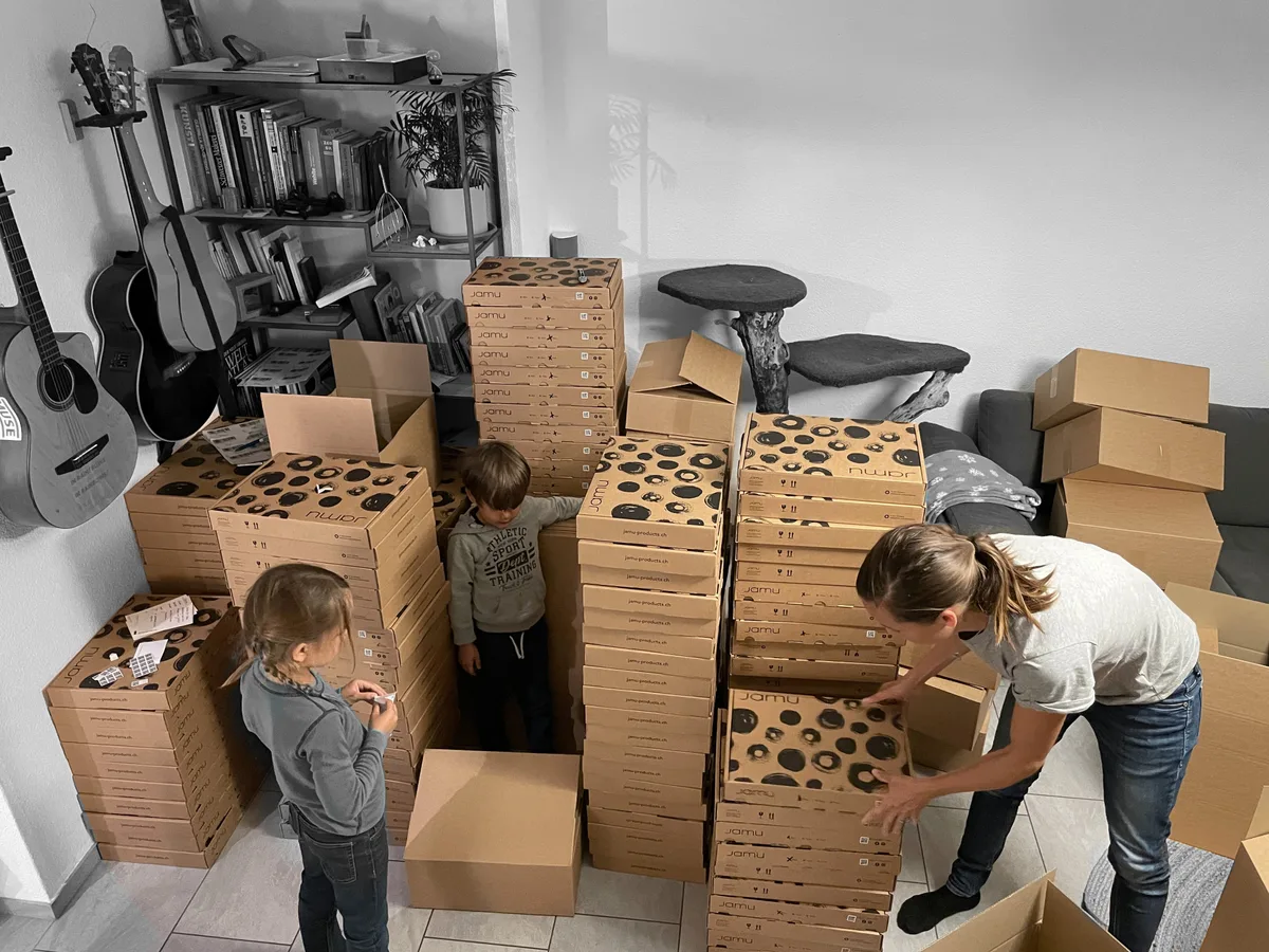 Kinder zwischen Verpackungskartons