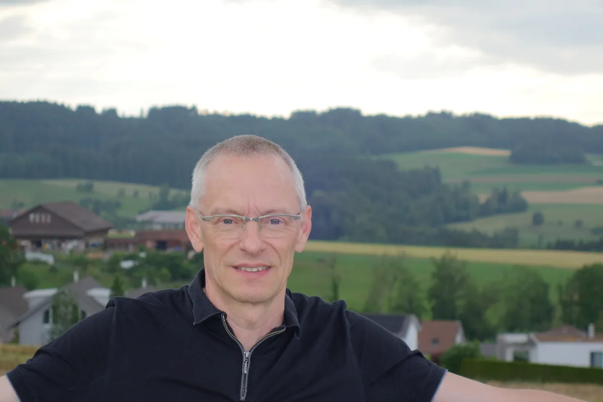 Man sieht einen Mann vor einem Dorf. 