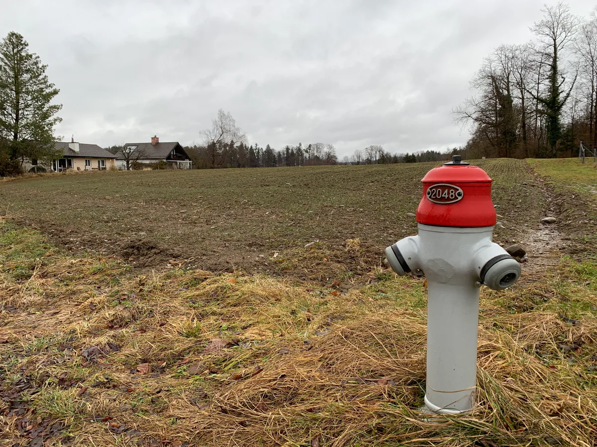 Ein Acker und daneben ein Hydrant.