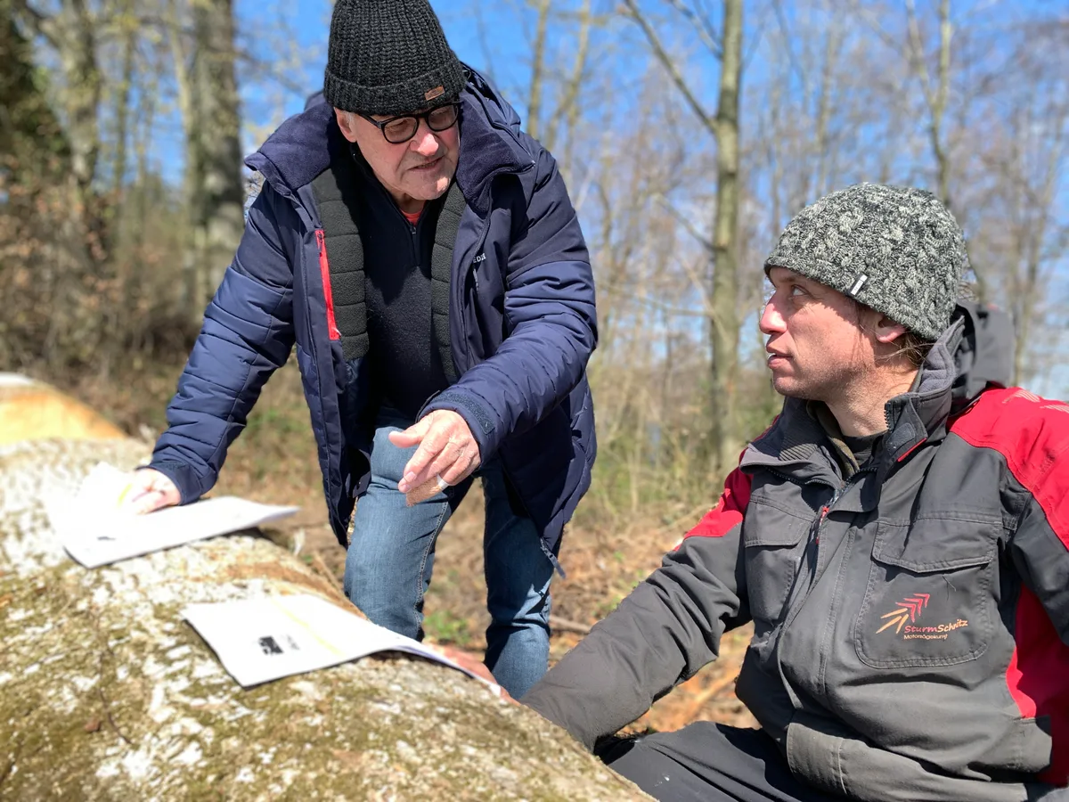 Initiator Werner Messikommer (links) erklärt dem Bäretswiler Förster und Motorsägenkünstler Pascal Sturm am Objekt, wie der neue Seegräbner Einbaum aussehen soll. Werner Messikommer (links) und der Motorsägenkünstler Pascal Sturm am Eschenstamm, aus dem ein Einbaum geschnitzt werden soll.