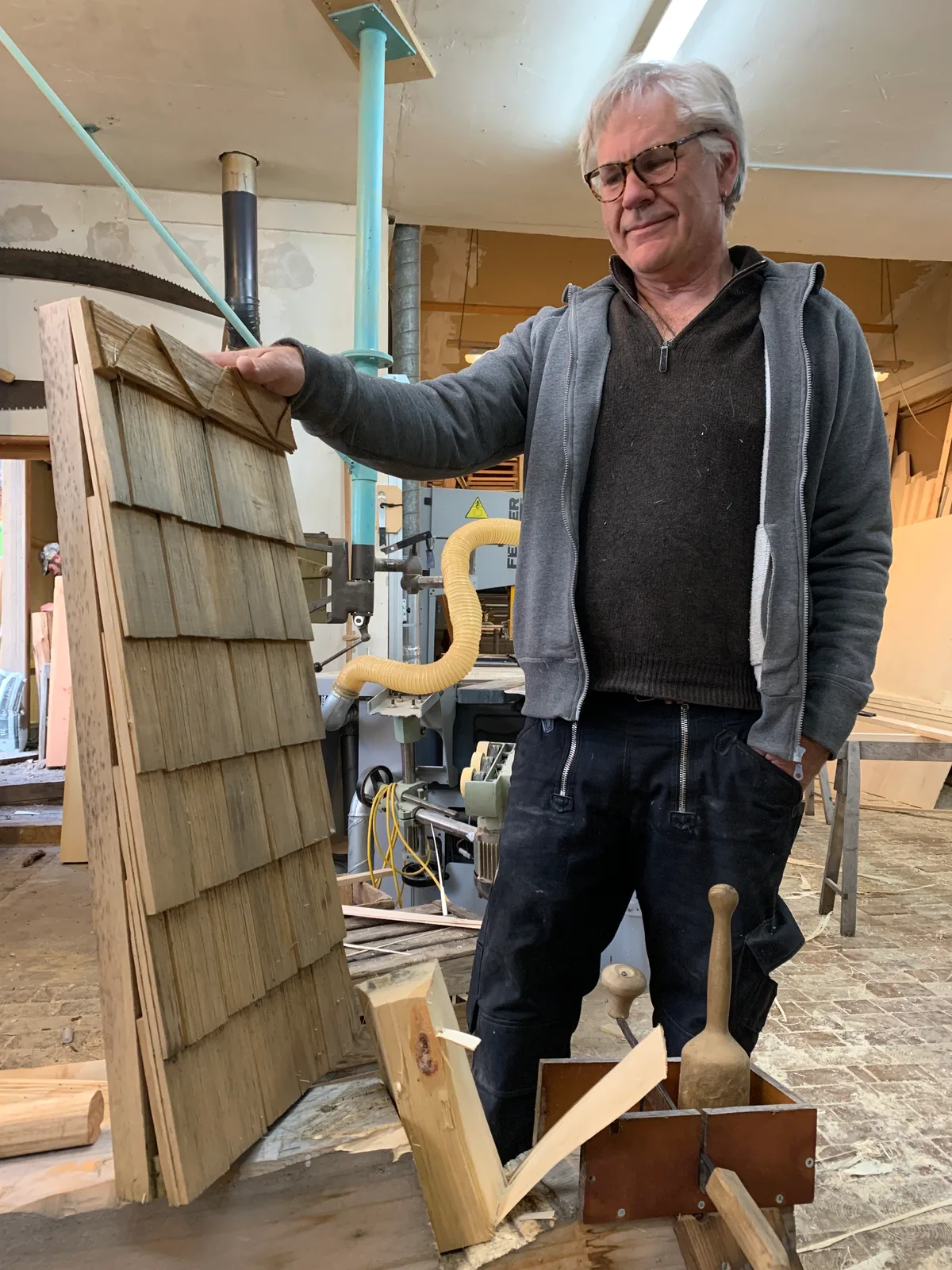Kaspar Mändli (Herr mit grauen Haaren) aus Ringwil demonstriert, wie er Schindeln herstellt. Der Bachtel-Kulm wird mit der Renovation komplett eingeschwindelt mit Schindeln von Mändli und seinem Sohn Vitus (roter Pulli)