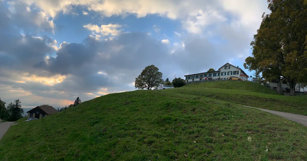Das Restaurant Bachtel-Kulm mit Baugespannen sowie ein Stall.  