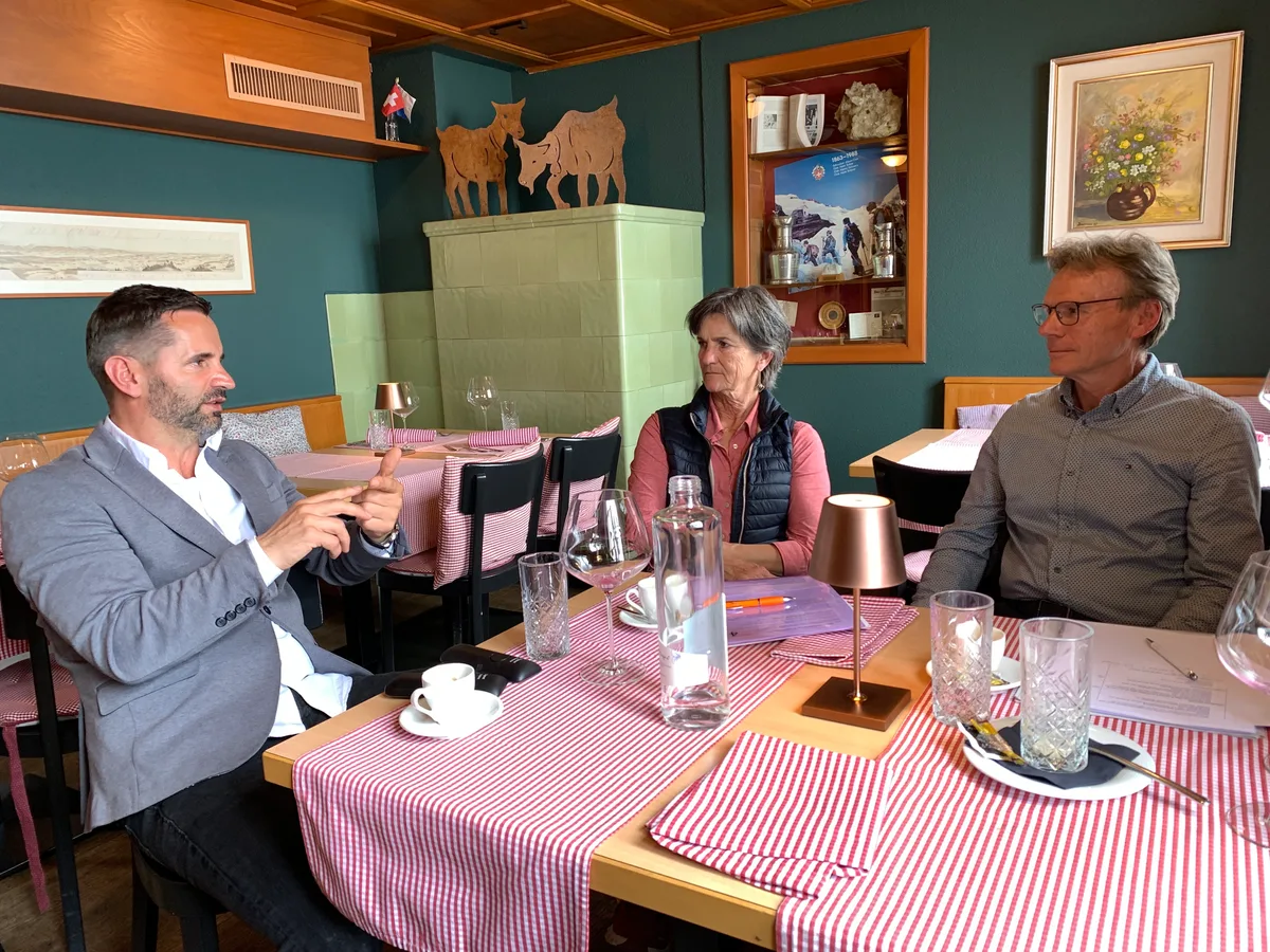 Wirt Aco Rastoder (mit Bart), Genossenschaftsvorstand Hubert Rüegg und Annemarie Beglinger, Mitglied Finanzkommission GBK, im Restaurant.