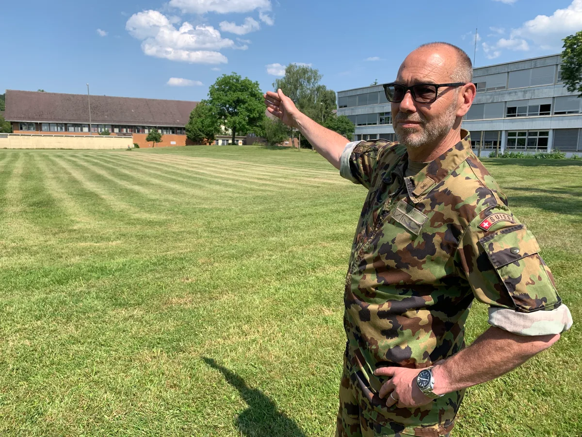 Oberst Pascal Martin in Uniform steht auf einer Wiese.