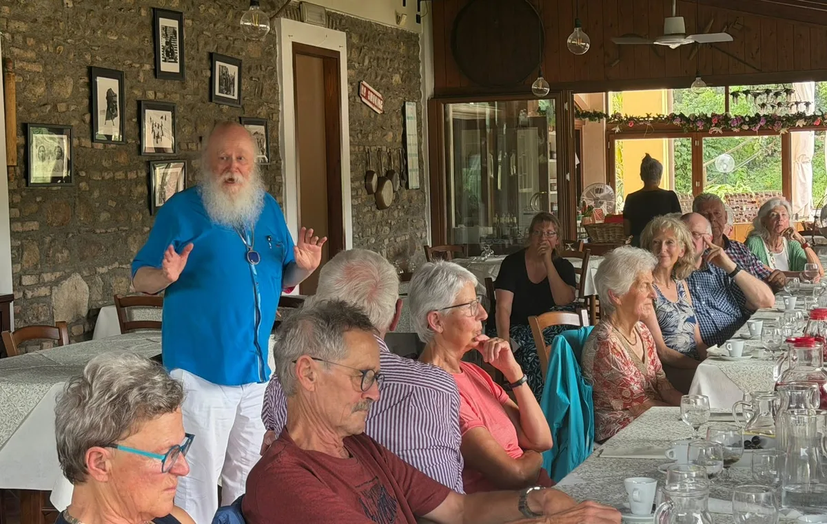 Nachdem alle satt sind, gibt Werner Bärtschi (stehend, blaues Hemd) eine erste Einführung ins Thema Oper. Aufnahmen der Lesereise nach Verona im August 2026.