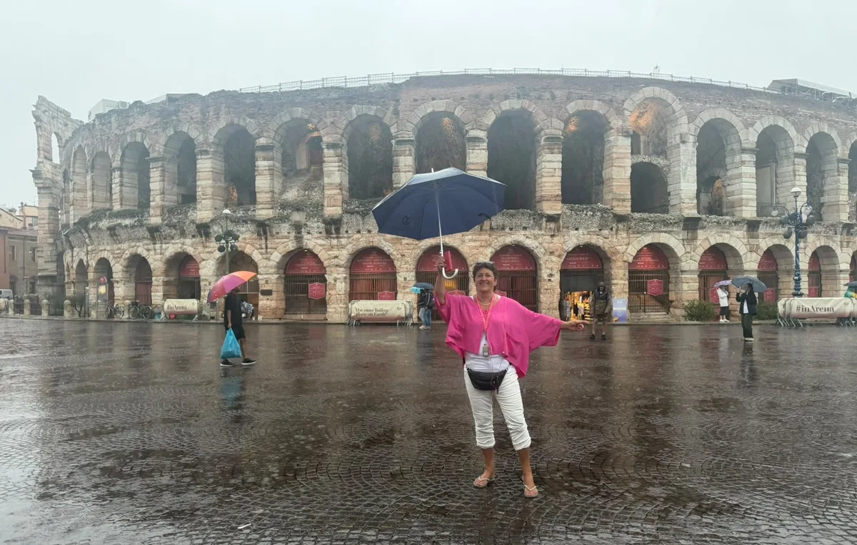 Trotz Regen sind die Teilnehmerinnen und Teilnehmer bester Laune und Wissbegierde – so auch Gisela Burri, die dank ihren offenen Schuhen auch keine nassen Socken hat. Aufnahmen der Lesereise nach Verona im August 2026.