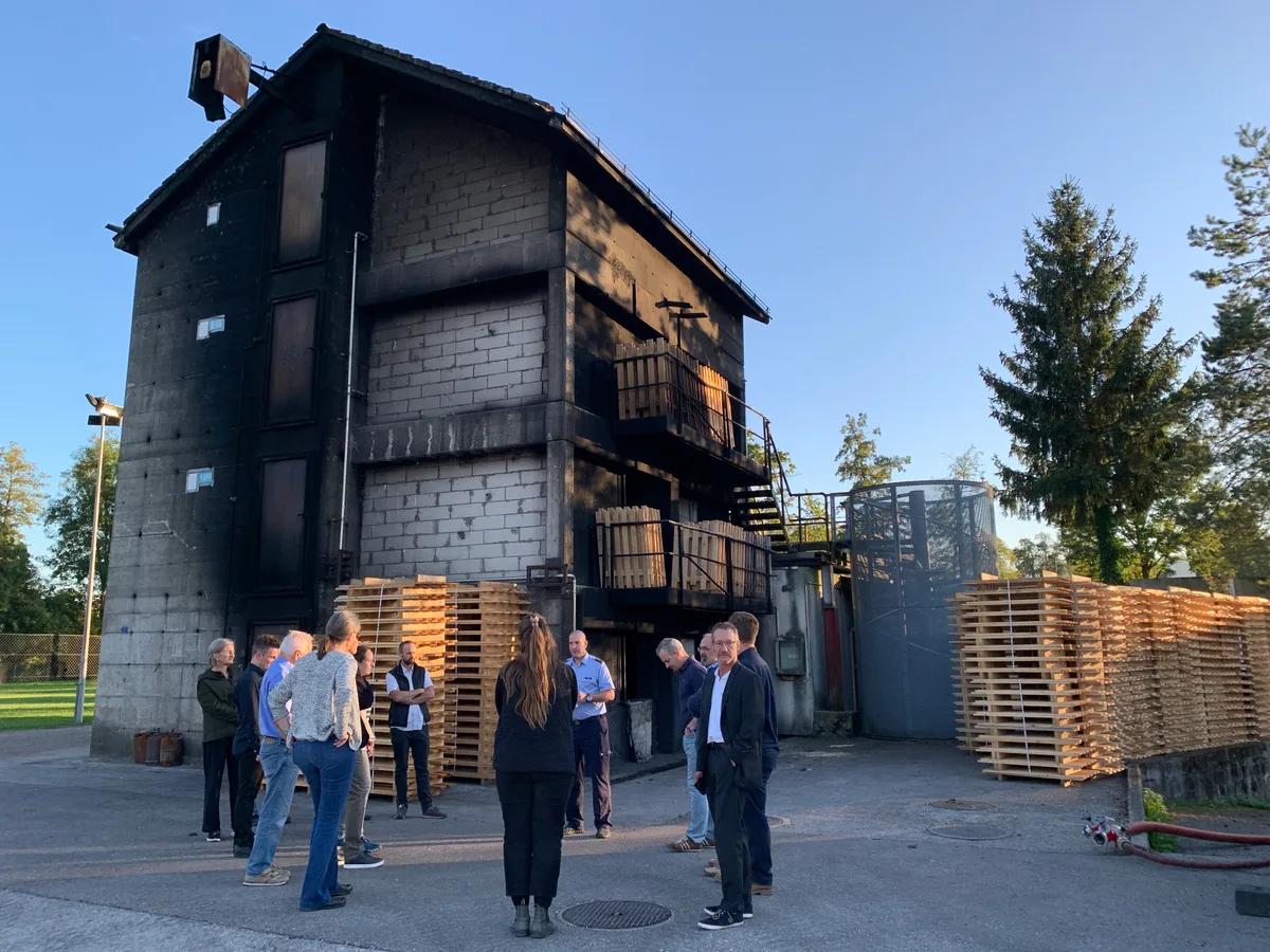 Am 25.9.2023 tagt das Ustermer Gemeindeparlament im Ausbildungszentrum Riedikon. Besichtigt wird auch das grosse Brandhaus (Haus 2), das ersetzt werden soll. Feuerwehrkommandant Sascha Zollinger  gibt Erklärungen ab. Im Bild: Parlamentarier vor dem Brandhaus 2.