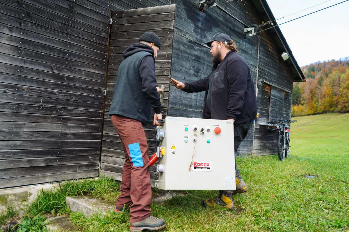Zwei Männer tragen eine Strombox.