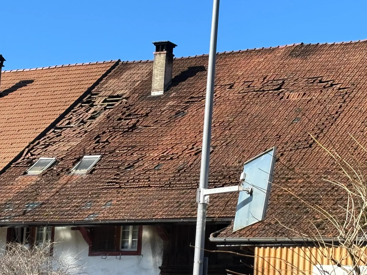 Haus, an dem sich die Ziegel vom Dach lösen. 