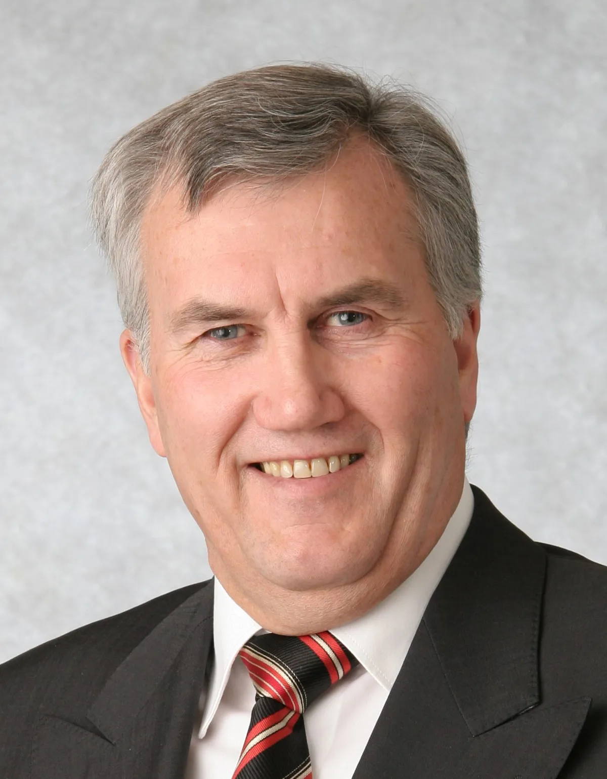Alter Mann mit Anzug und Krawatte.