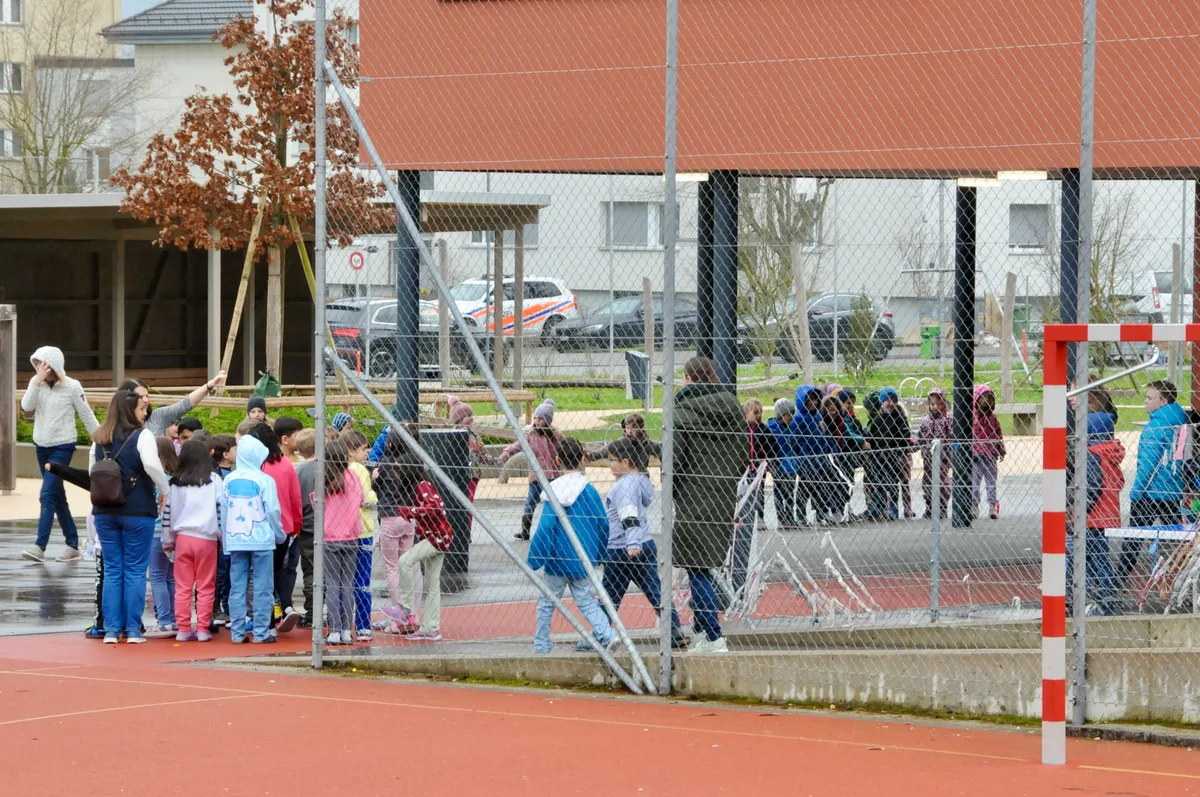 Man sieht Kinder und Lehrpersonen zum Sammelplatz strömen.