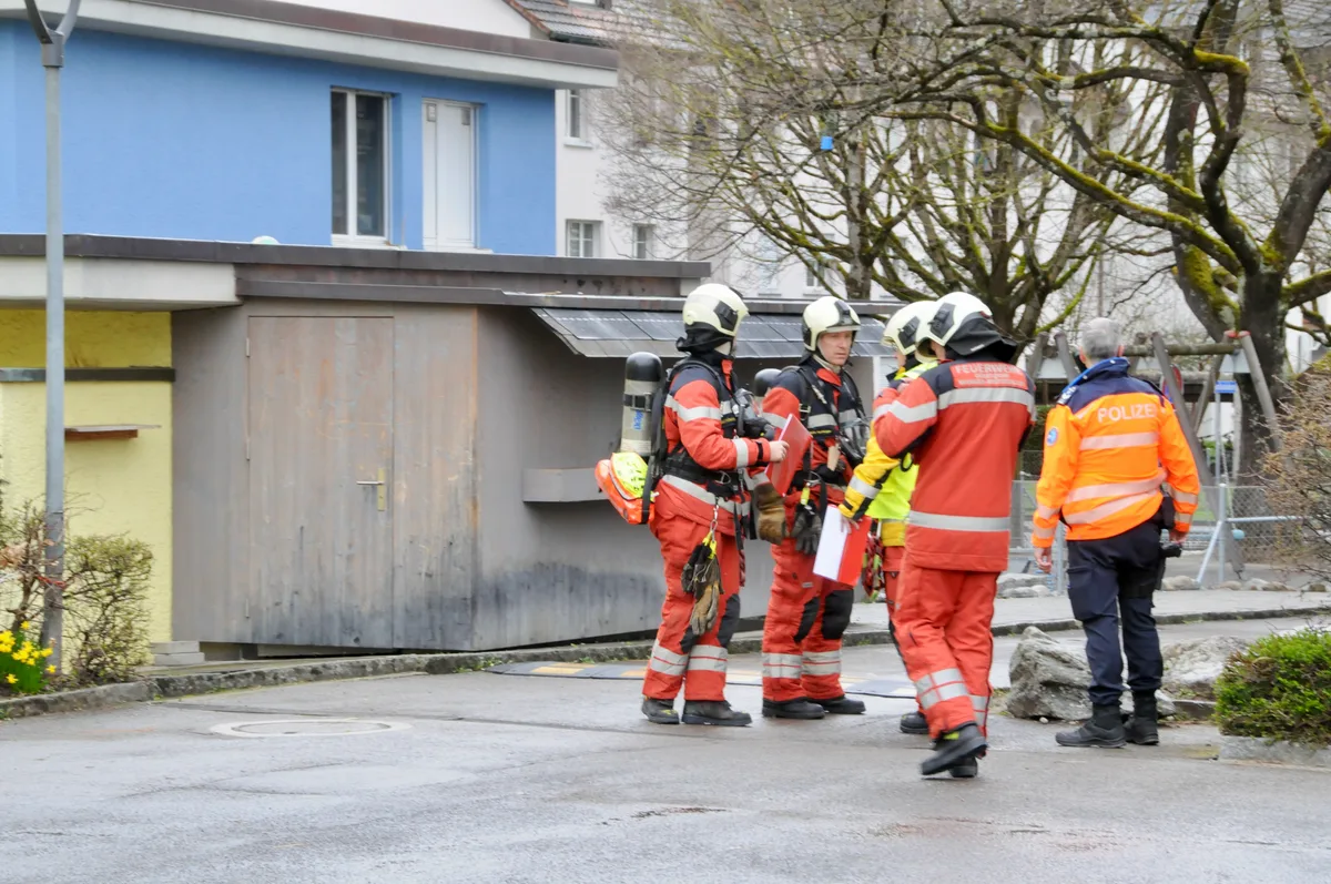 Man sieht Feuerwehr-Einsatzkräfte vor dem Schulhaus.