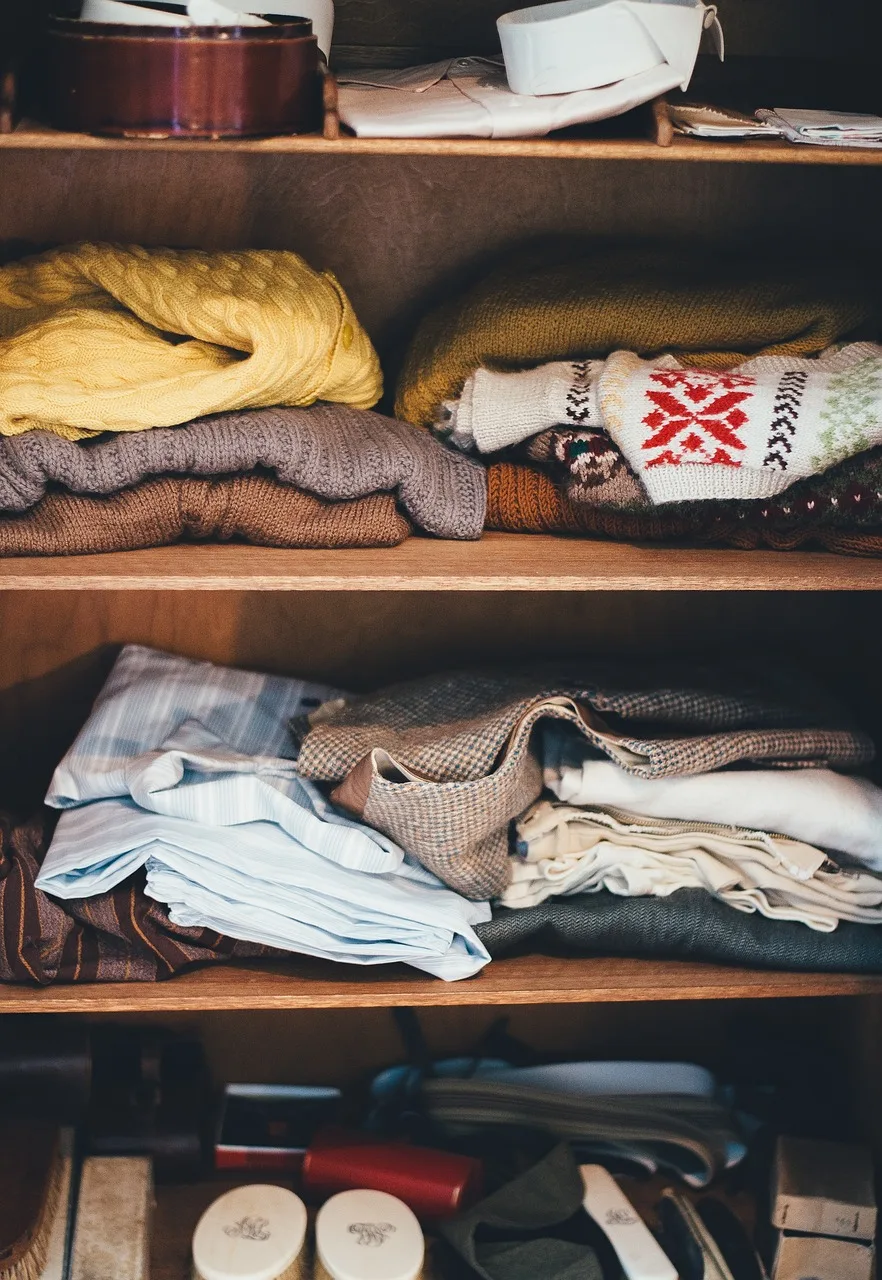 Auf dem Bild ist ein geöffneter Kleiderschrank zu sehen.