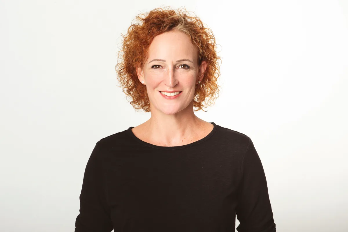 Porträt einer Frau mit roten Locken.