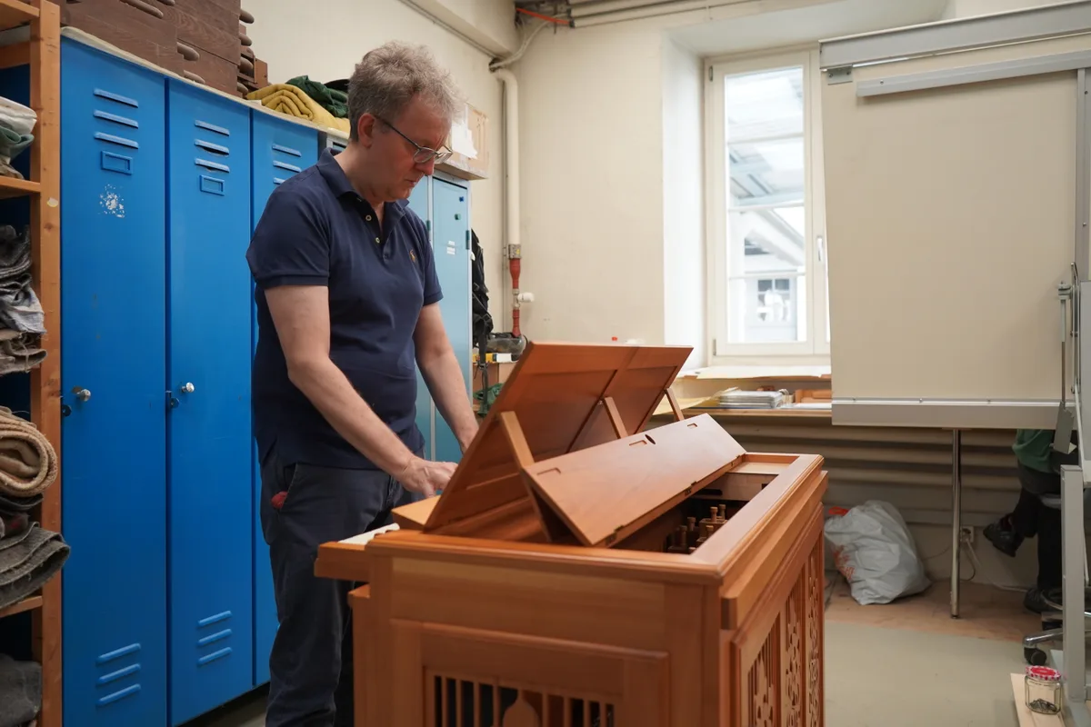 Ein Mann spielt auf einer Truhenorgel.