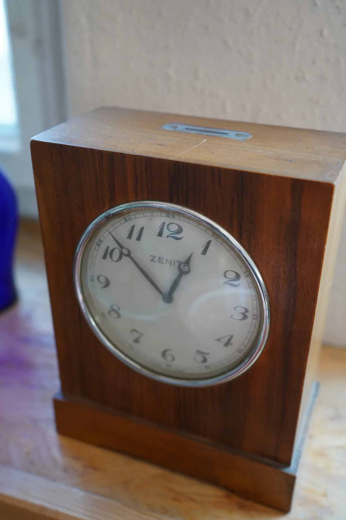 Eine Standuhr mit einem Münzschlitz, in den Hevetia Versicherungen eingraviert ist. Die Uhr lief nur, wenn 1 Silberfranken eingeworfen wurde. Sie diente Sparzwecken.