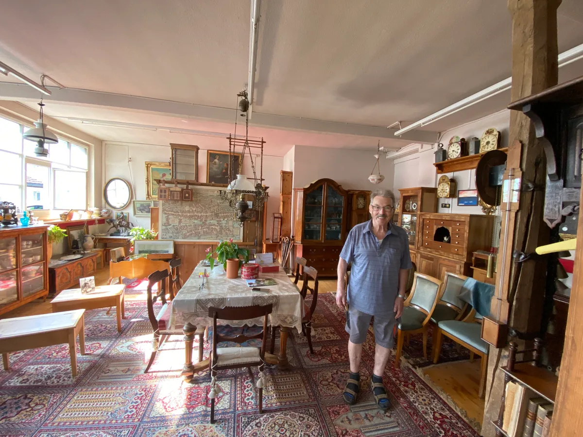 Fundgrube und Schatztruhe in einem: Manfred Maier in seinem «Antik-Stübli» in Robenhausen. Ein alter Mann steht in seinem Laden voller antiker Möbel.