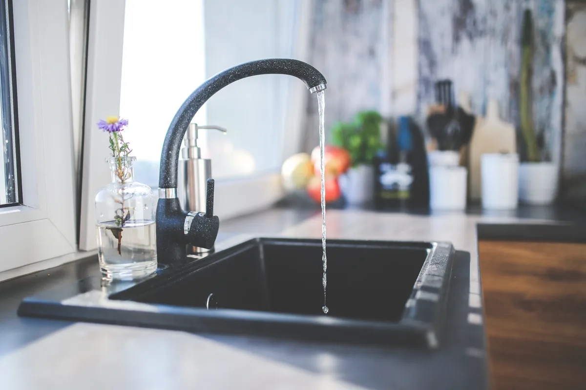 Wasser fliesst aus einem Wasserhahn.