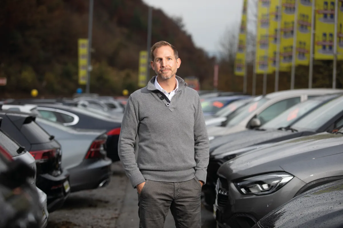 Patrick Liechti, Geschäftsführer der Autoshow Aathal. Man sieht Patrick Liechti, Geschäftsführer der Autoshow Aathal zwischen vielen Autos stehen