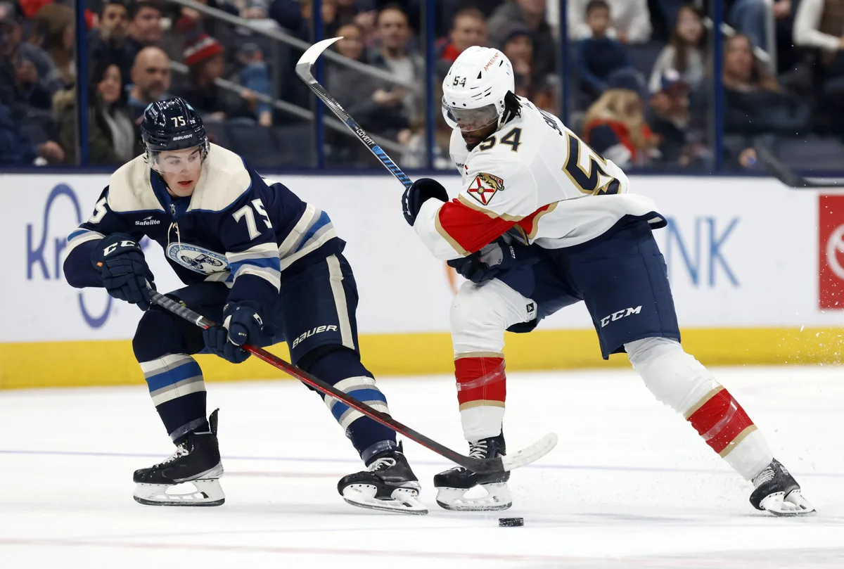 Columbus Blue Jackets defenseman Tim Berni, left, works for the puck in front of Florida Panthers forward Givani Smith