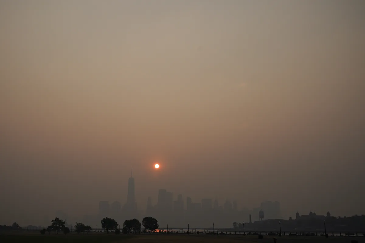 The sun rises over a hazy Manhattan skyline as seen from Jersey City, N.J., Thursday, June 8, 2023. Intense Canadian wildfires are blanketing the northeastern U.S. in a dystopian haze, turning the air acrid, the sky yellowish gray and prompting warnings for vulnerable populations to stay inside. (AP Photo/Seth Wenig)