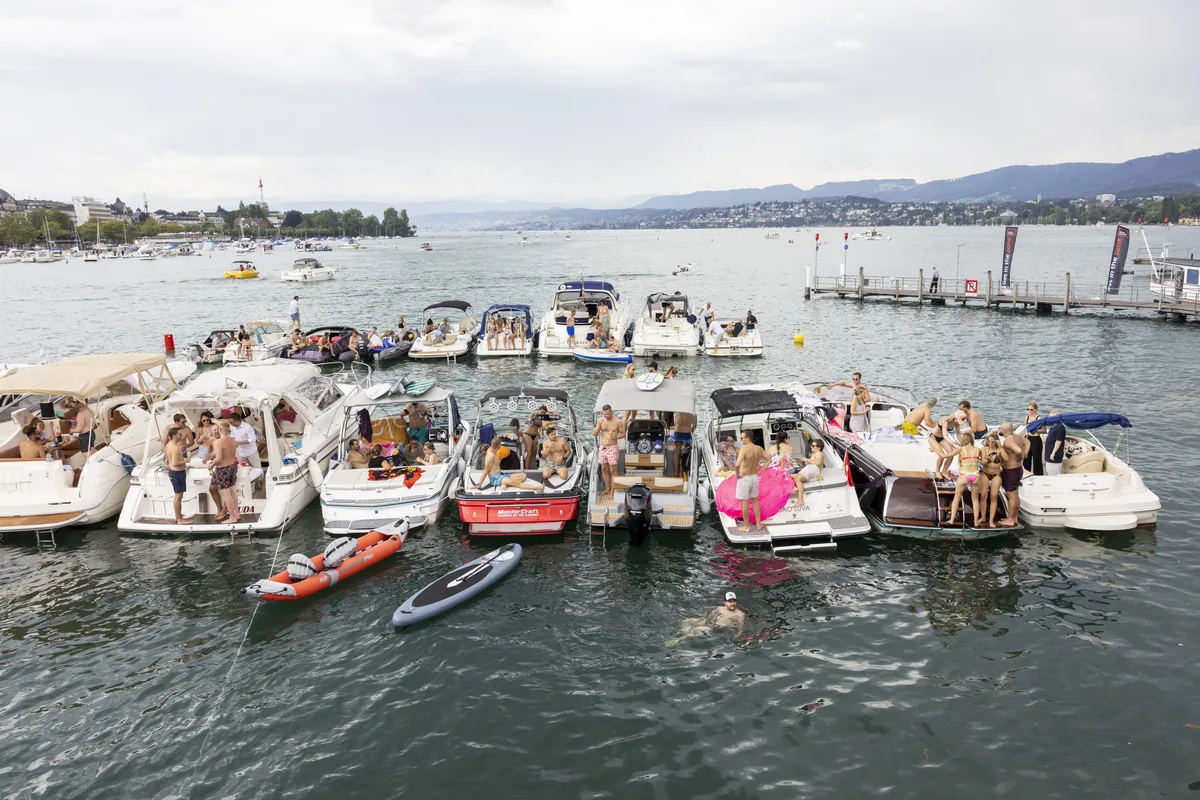 Participants are seen on Boats at the shore of Lake Zurich during the 30th Street Parade in Zurich, Switzerland, Saturday, August 12, 2023. The annual dance music event Street Parade runs this year under the claim