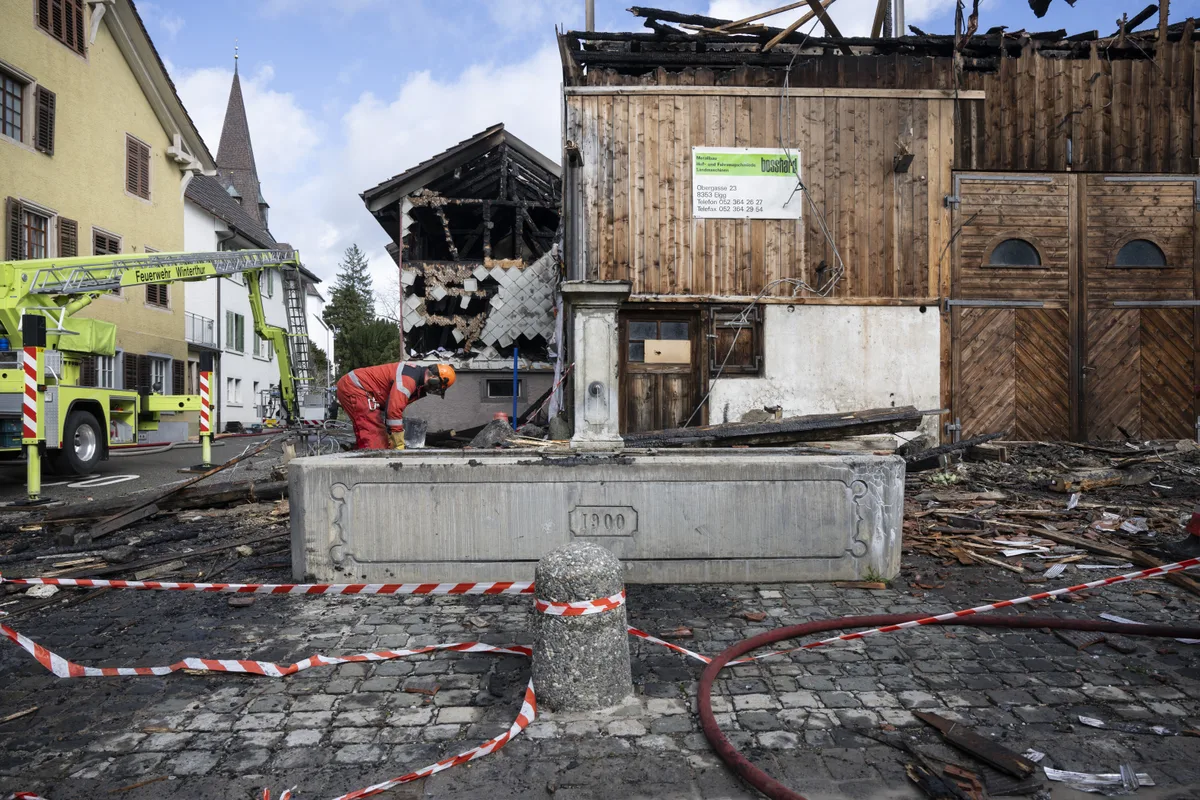 Die Feuerwehren waren bis am Samstagnachmittag mit den Lösch- und Aufärumarbeiten beschäftigt. Feuerwehrmaenner helfen beim Brand am Samstag, 16. Maerz 2024 in Elgg. Mehrere Gebaeude sind im Dorfzentrum von Elgg ZH in der Nacht auf Samstag in Brand geraten. Mehrere Dutzend Personen mussten laut der Polizei evakuiert werden.