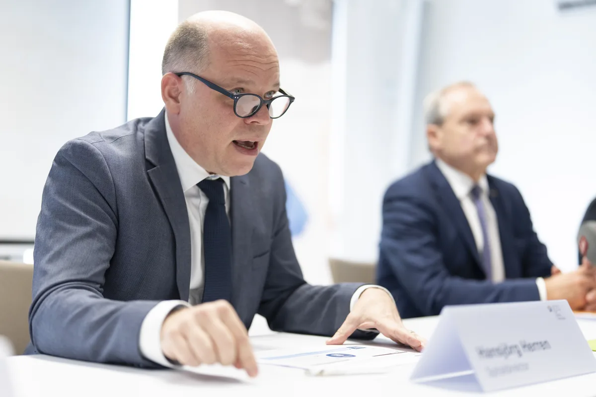 Hansjörg Herren, Spitaldirektor des GZO Spitals Wetzikon, spricht über die Sanierungspläne. Zwei Männer hinter einem Pult.