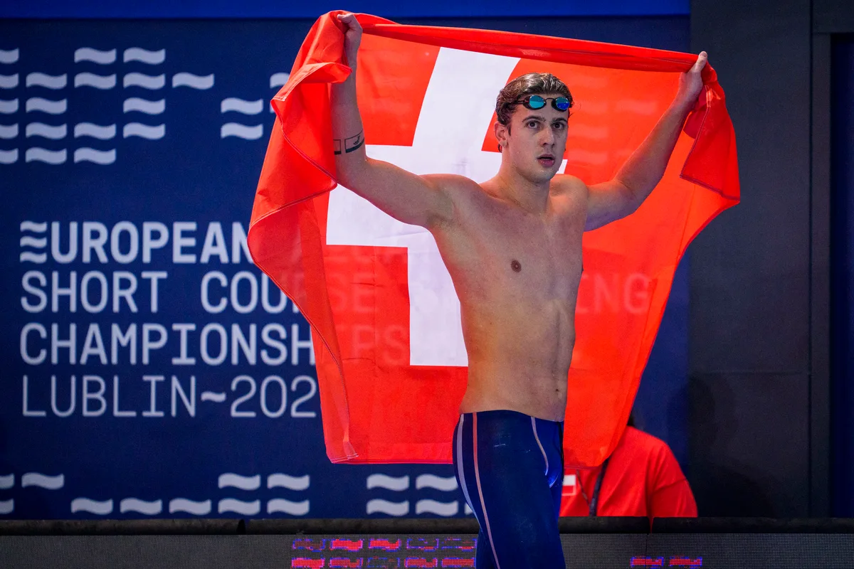 Swiss Swimmer Noe Ponti celebrates with a Swiss flag on his way out after winning in the Men's 200m Butterfly Final during the European Aquatics Short Course Swimming Championships in Lublin, Poland, Sunday, Dec. 7, 2025. (KEYSTONE/Patrick B. Kraemer)