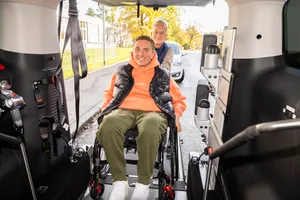Ein Fahrer von Tixi dem Fahrdienst für Menschen mit einer Behinderung Behinderte schiebt einen Rollstuhlfahrer in sein Auto. Ein Fahrer von Tixi dem Fahrdienst für Menschen mit einer Behinderung Behinderte schiebt einen Rollstuhlfahrer in sein Auto.