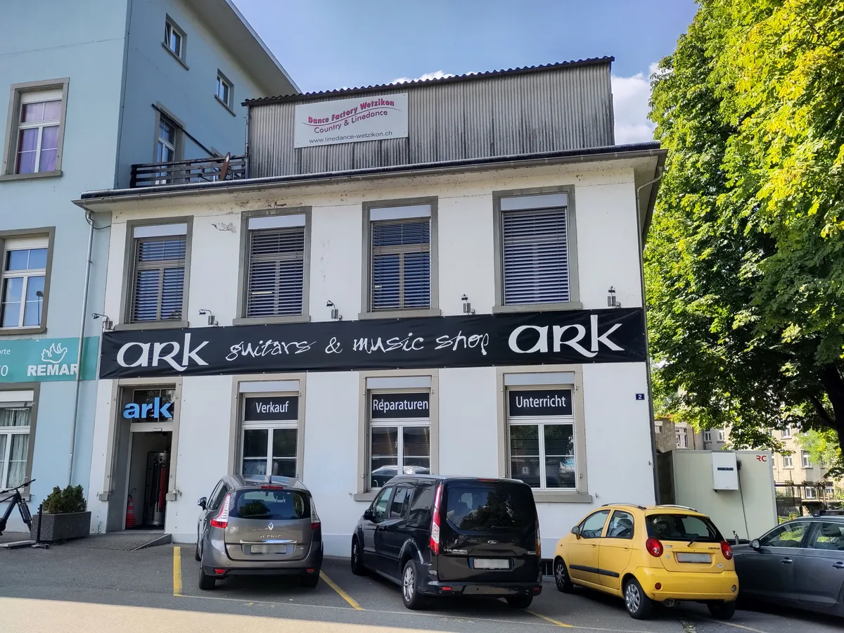Vor dem Ladengeschäft stehen Autos.