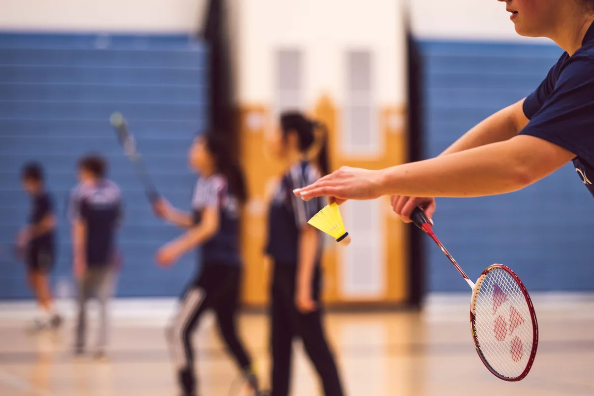 Ein Mann macht einen Aufschlag beim Badminton.