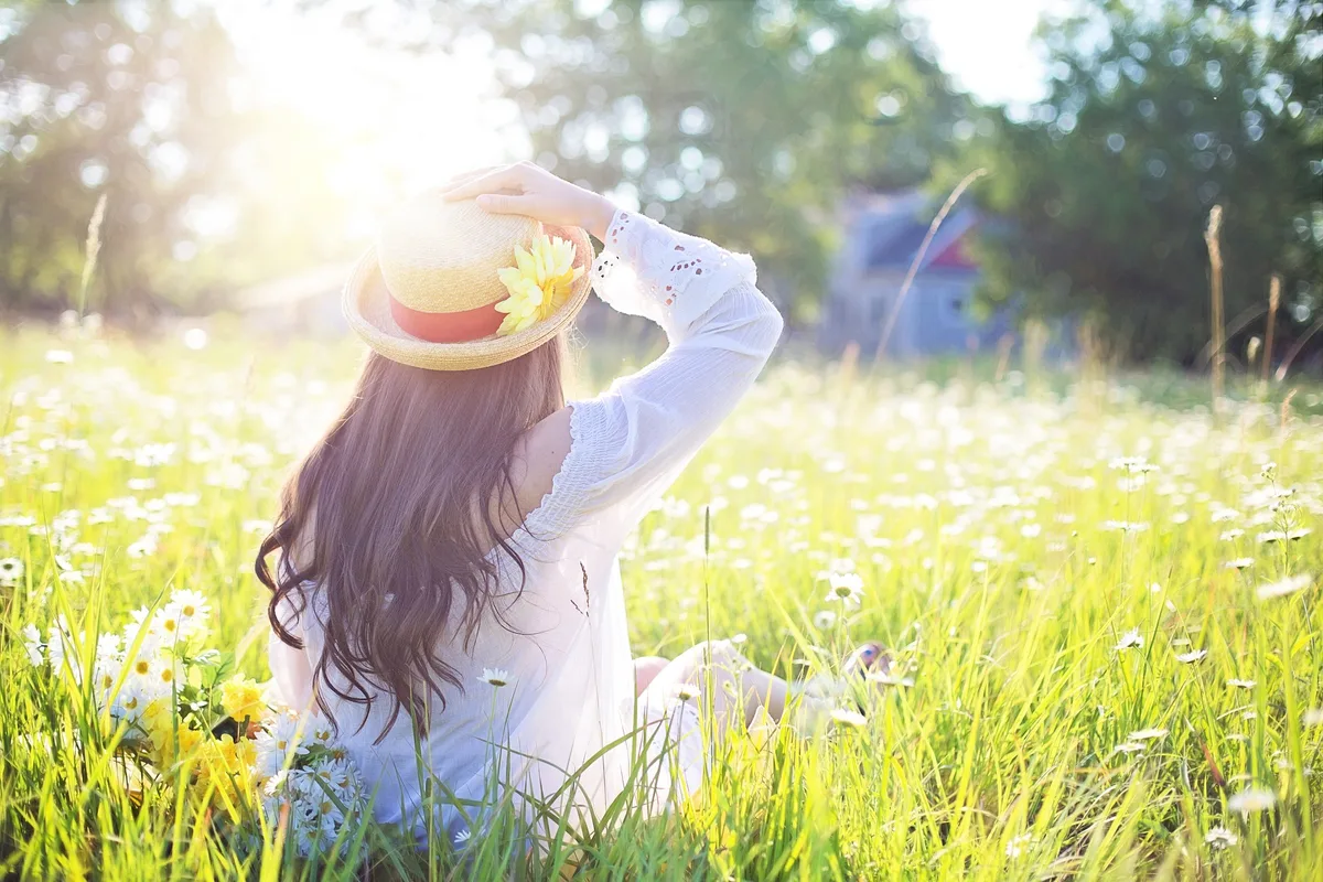 Weil es der ein oder andere vergessen haben könnte: So sieht es aus, wenn die Sonne scheint. (Symbolbild) Eine Frau sitzt in einer Wiese.