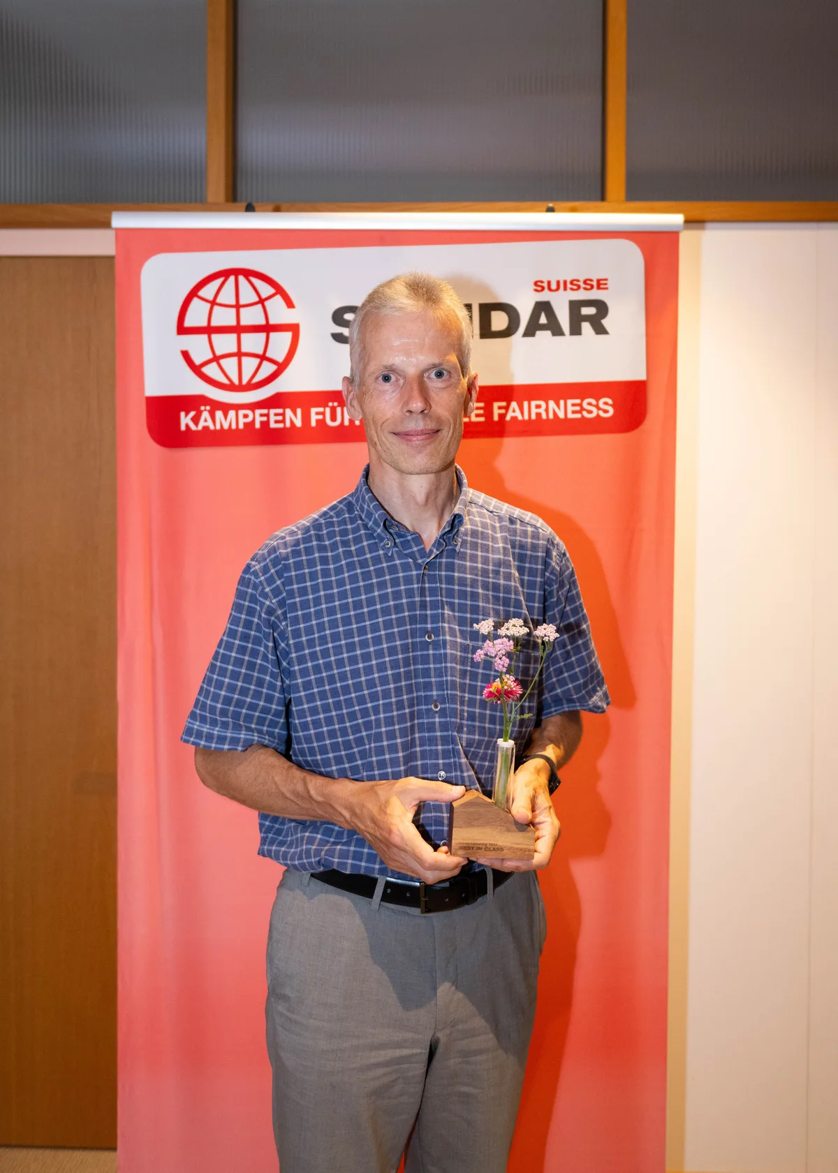 Ein Mann hält Blumen in der Hand.