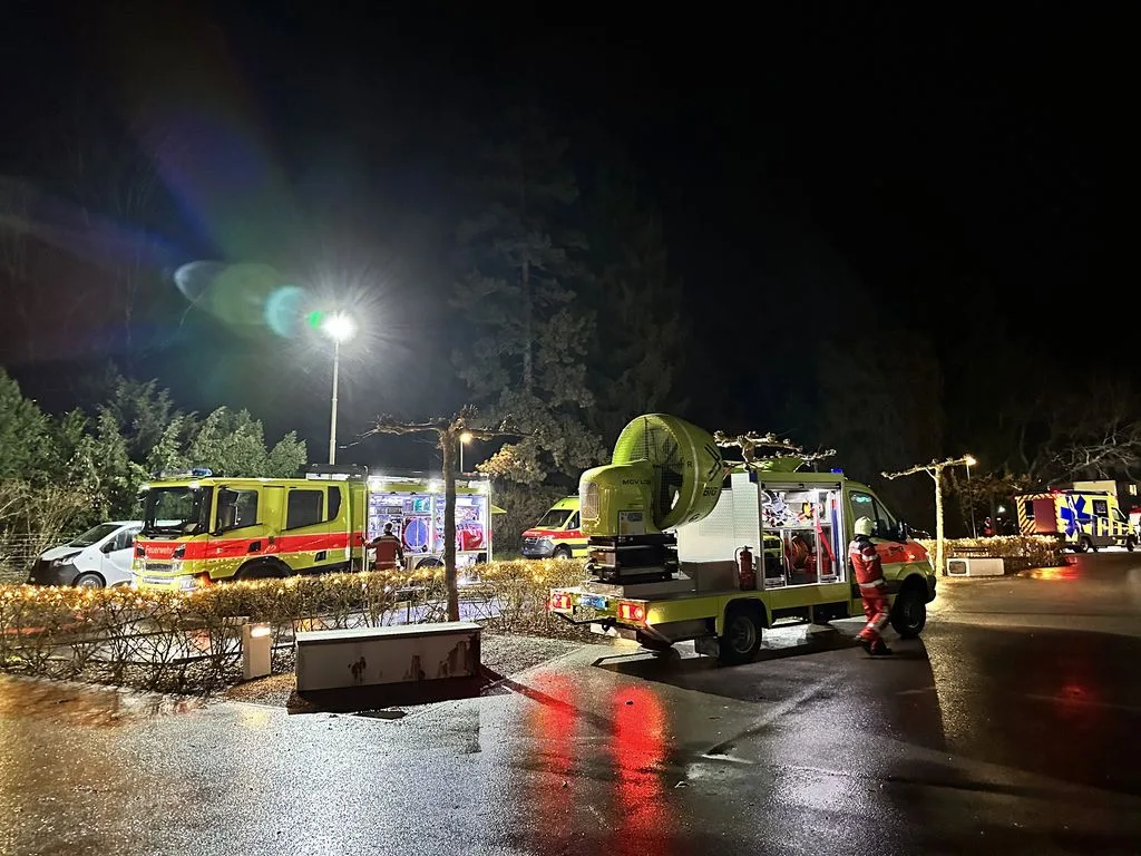Auf einem Platz stehen im Dunkeln zwei Feuerwehrautos.