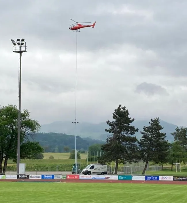 Helikopter (rot) über einem fussballfeld.