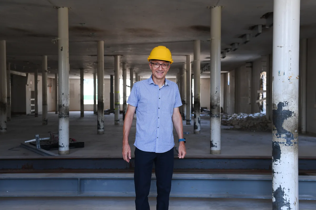 Ein Mann mit Helm steht auf einer Baustelle.